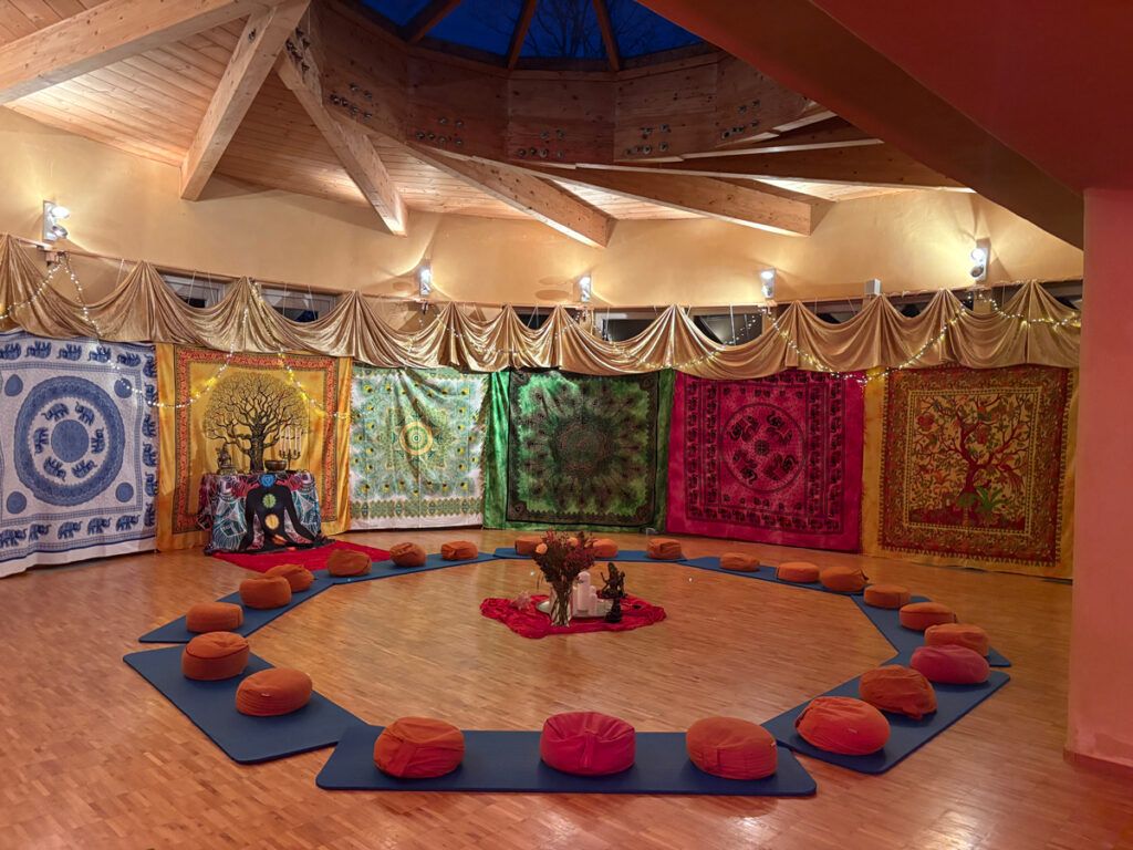 Gemütlicher Sitzkreis in Seminarraum mit, mit Ritualtüchern abgehängten Fenstern