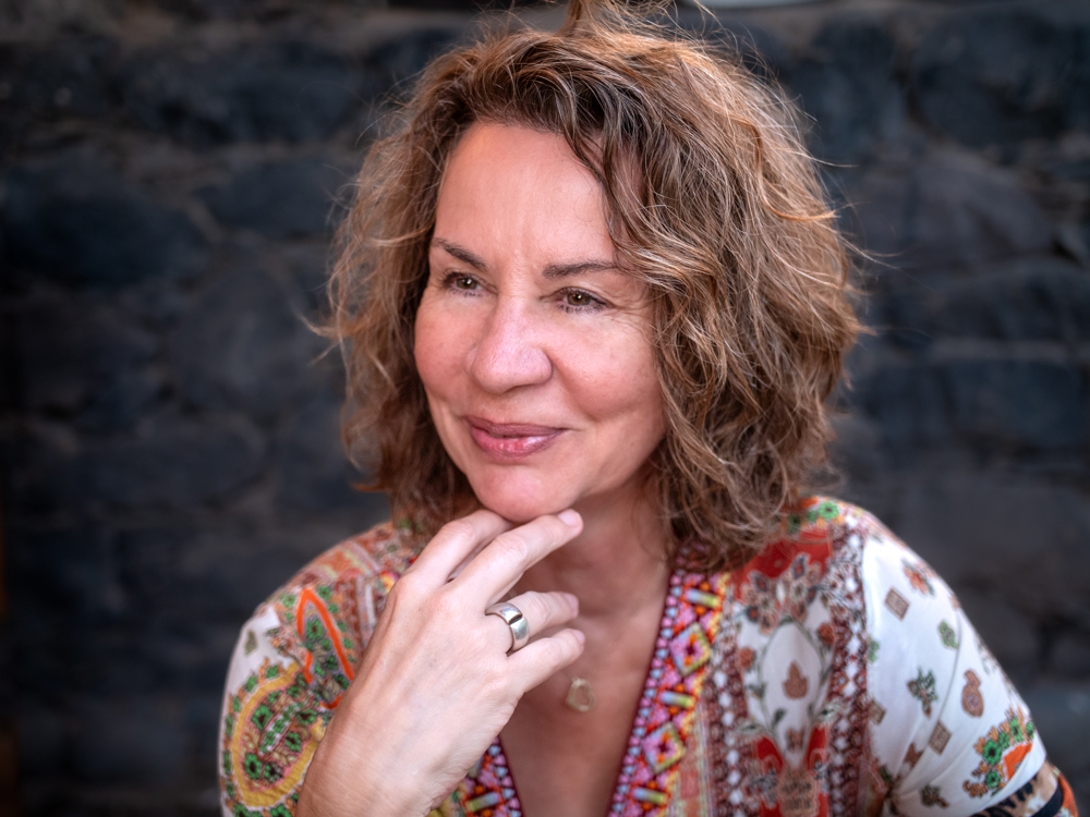 Porträt von Martina Körber mit freundlichem Lächeln vor dunklem Hintergrund