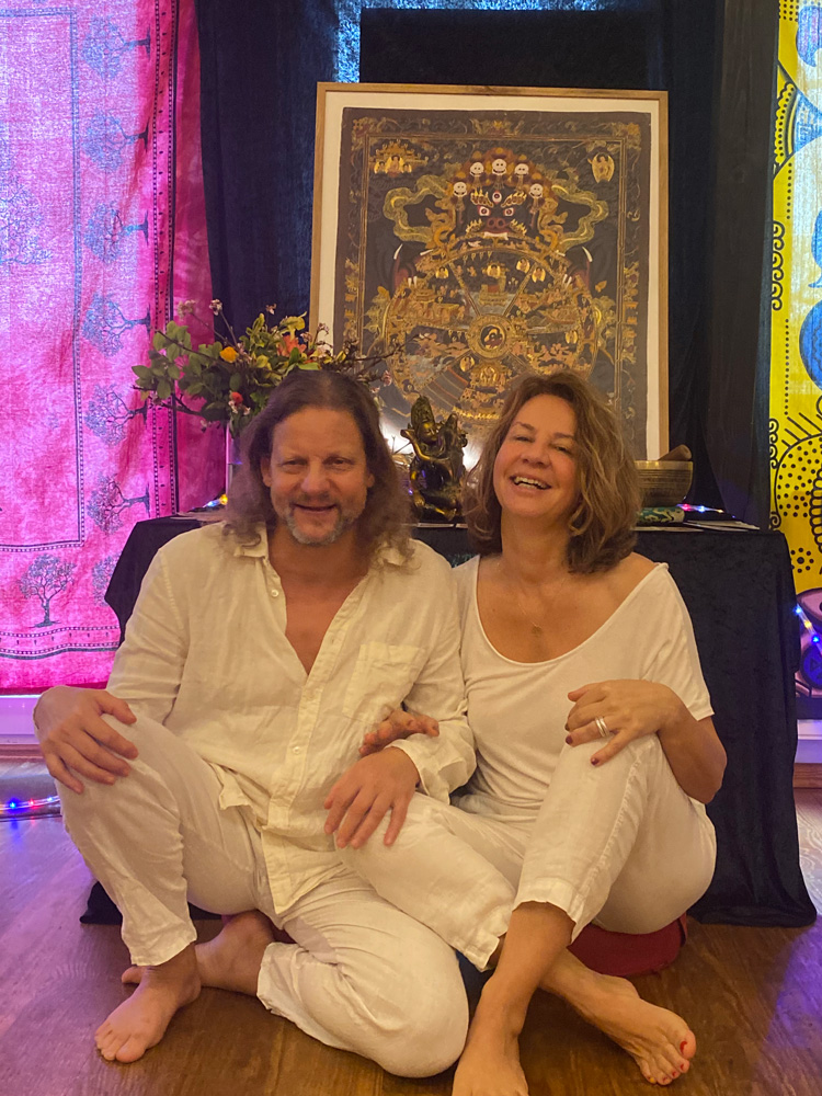 Christian und Martina sitzen vor einem Ritualaltar und lachen