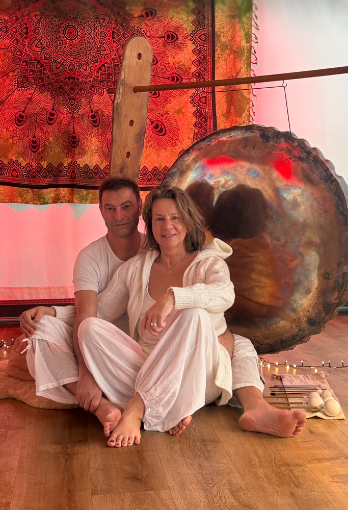 Hans-Jürgen und Martina sitzen vor einem großen Gong